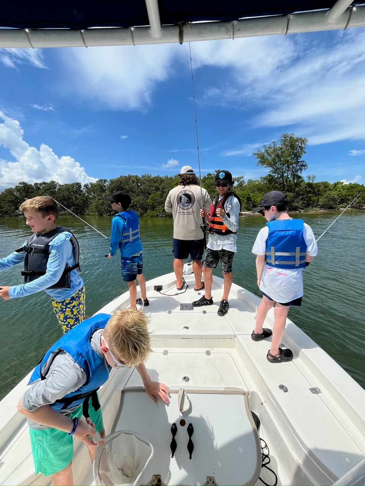 Group of kids on a fishing boat with life vests